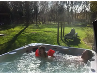 Grått PassionSpa Relax Spabad Pure Collection med bubblande vatten och två personer som slappnar av