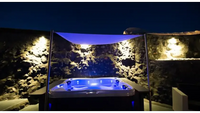 Blåupplyst PassionSpa Renew Spabad Pure Collection med vit exteriör under tak nattetid