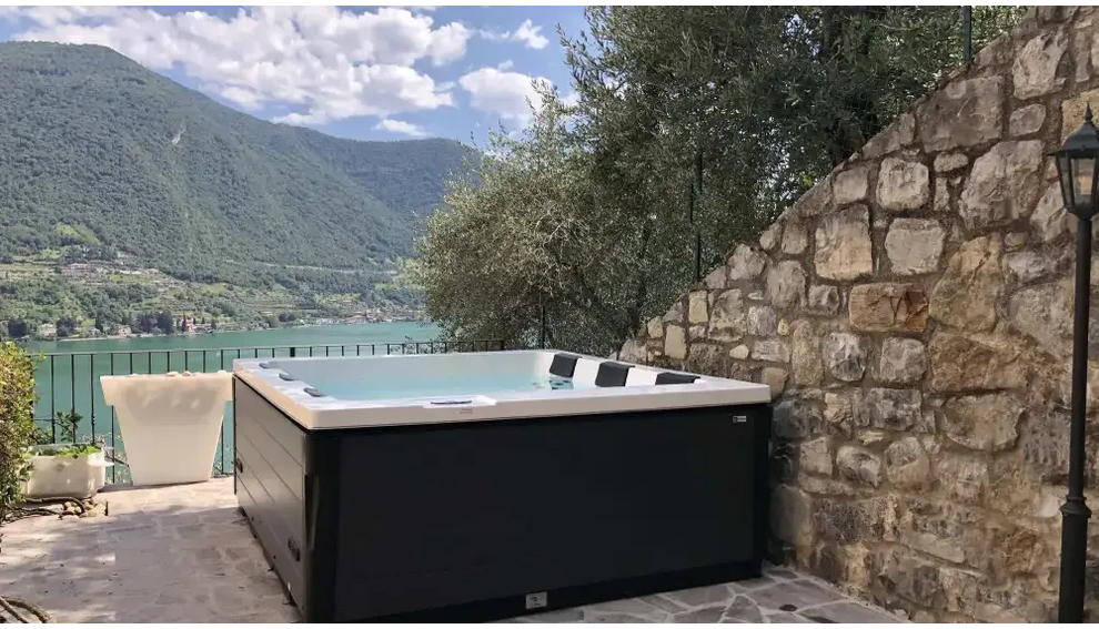 PassionSpa Serene 6 eldstadsspabad i svartvit modern design mot stenvägg