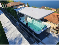 Grå PassionSpa Spirit Deep Swim Spa med vit lock och svarta jetstrålar på stenaltan vid havet