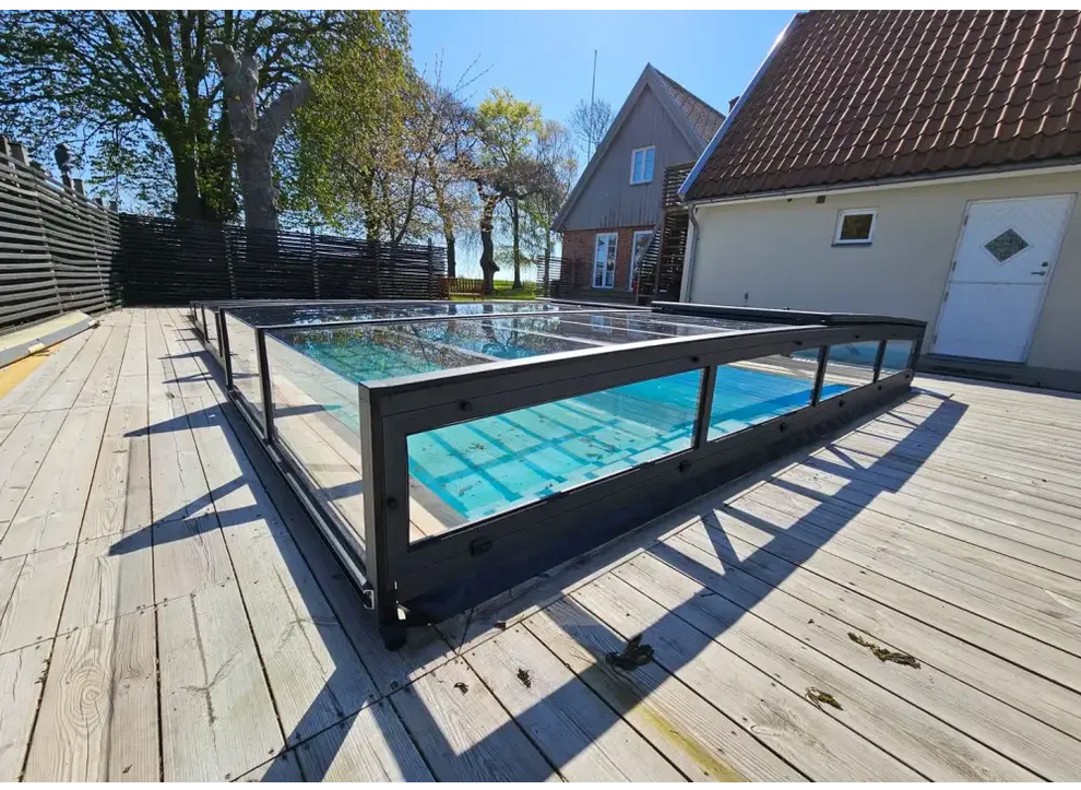 Modern glashägnad pool med Pooltak Icon Kit, svart ram och blå vatten
