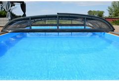 Pooltak Nivo Kit 1060B med svart bågad pooltäckning och transparenta paneler över blå pool