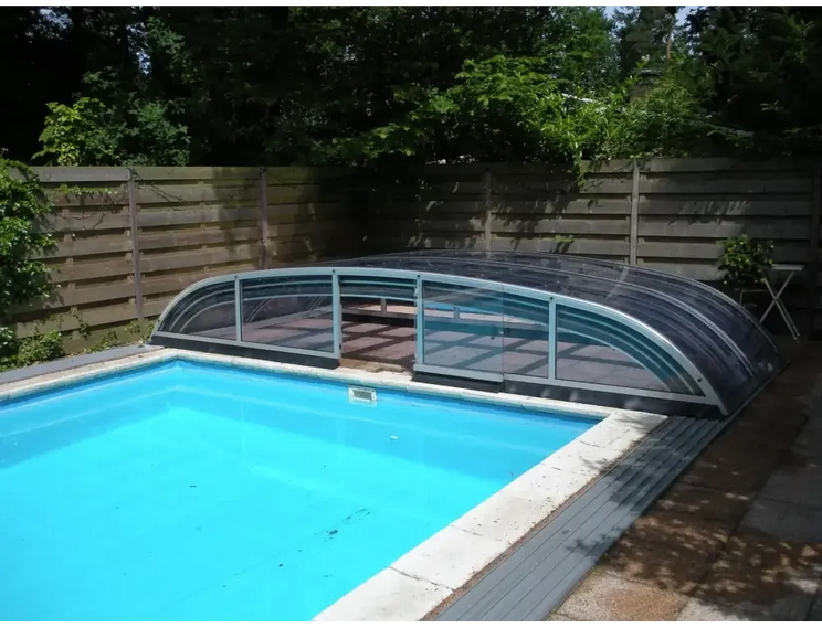 Pooltak Nivo Kit i transparent glas med metallram över blå pool
