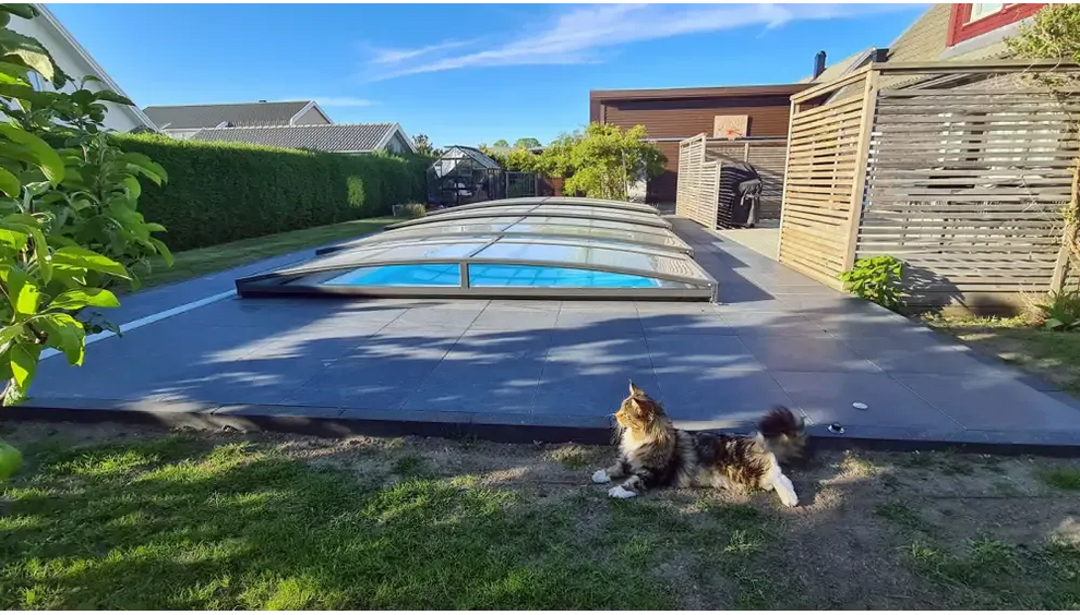Pooltak Sydney i blåtonat glas med slank metallram över blå pool