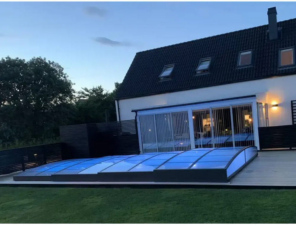 Ultra lågt pooltak med mörk ram över blå pool i glasrum