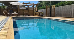Exklusiv 12mm rektangulär pool med inbyggda trappor, klarblått vatten och träkanter