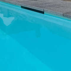 Pooltime Exklusiv 12mm rektangulär pool med klart turkost vatten och grå betongplattor