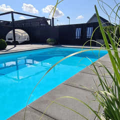 Pooltime Exklusiv 12mm rektangulär pool med kristallklar blå vatten och grönt gräs