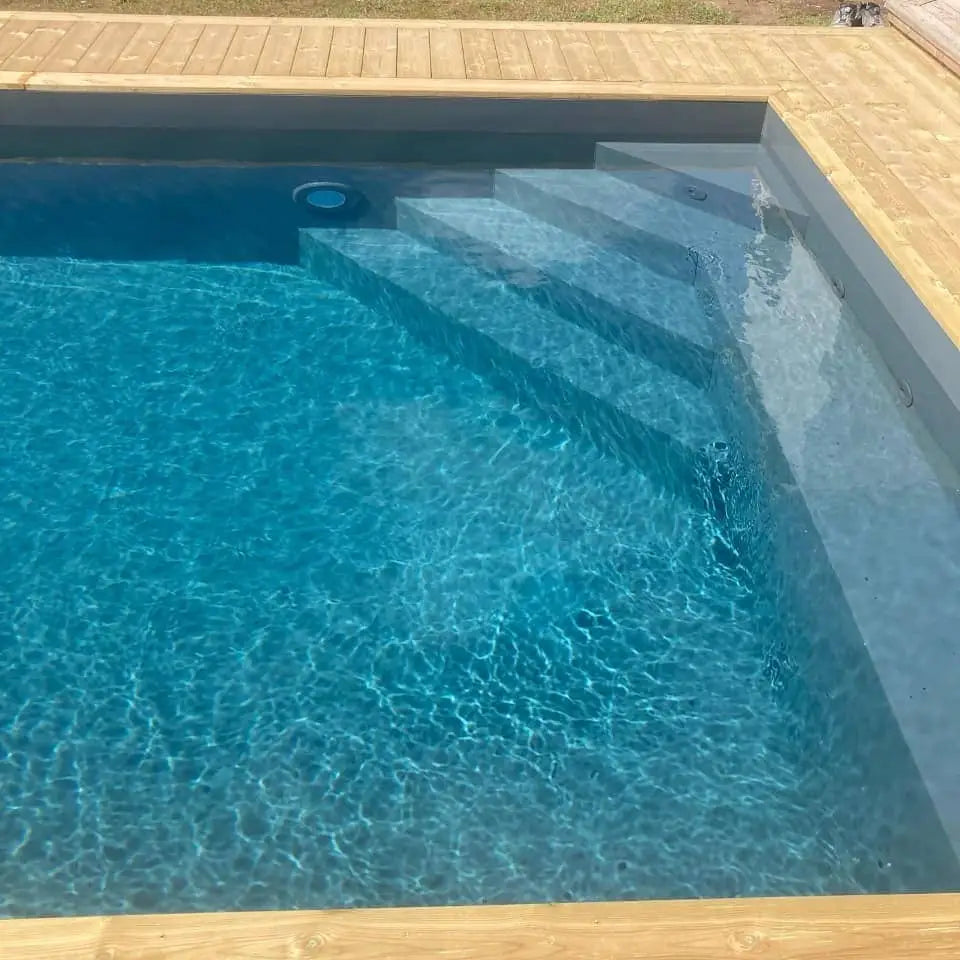 Pooltime Exklusiv 12mm rektangulär pool med klart blått vatten och trädäckssteg