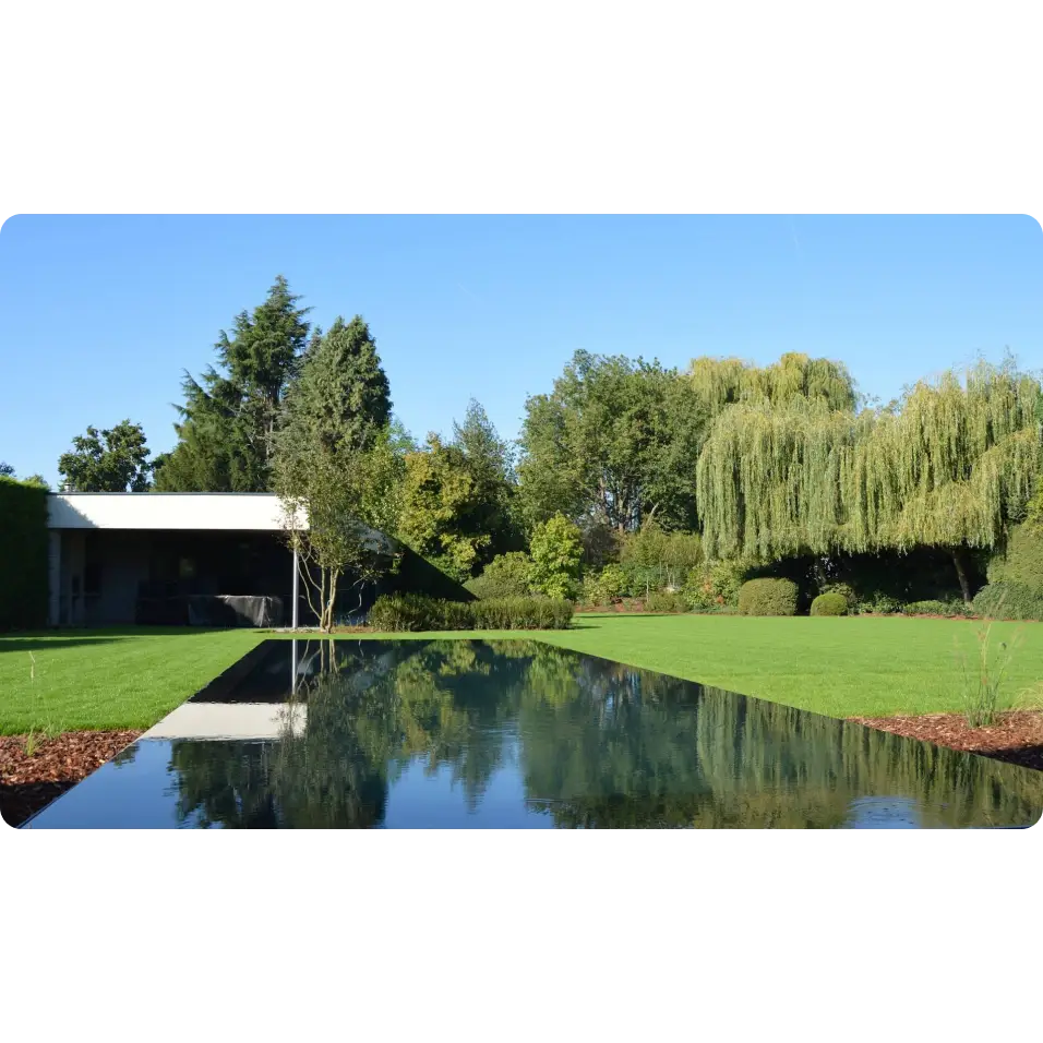 Modern vit hus med Pooltime Exklusiv Infinity pool bland gröna träd