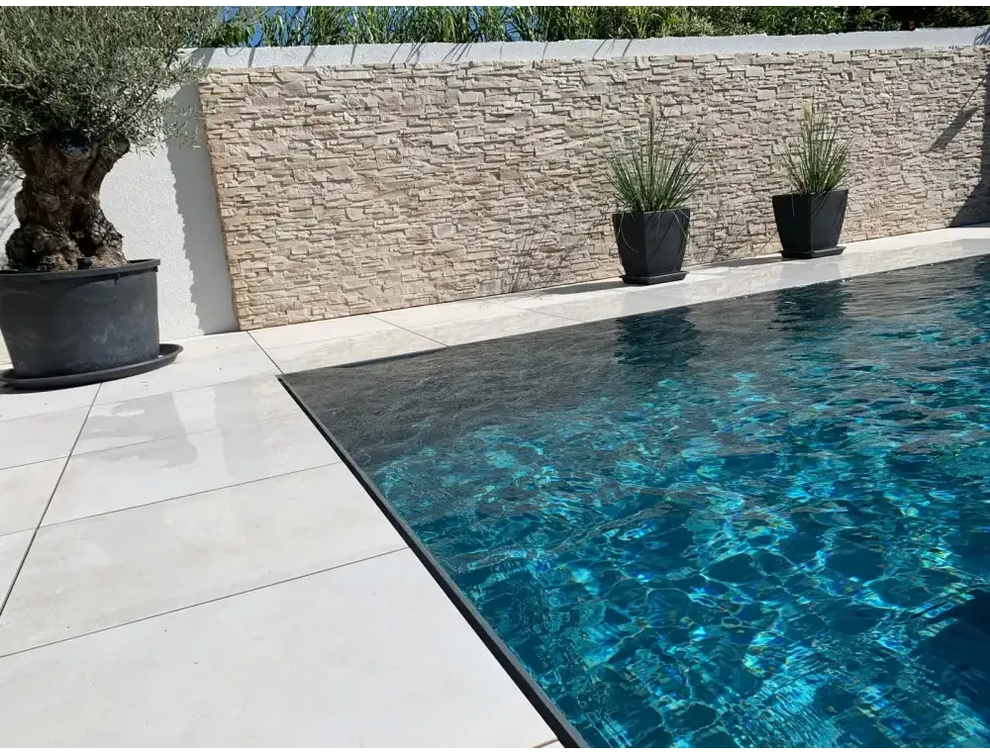 Pooltime Exklusiv overflow med klart turkost vatten och svarta kakelkanter
