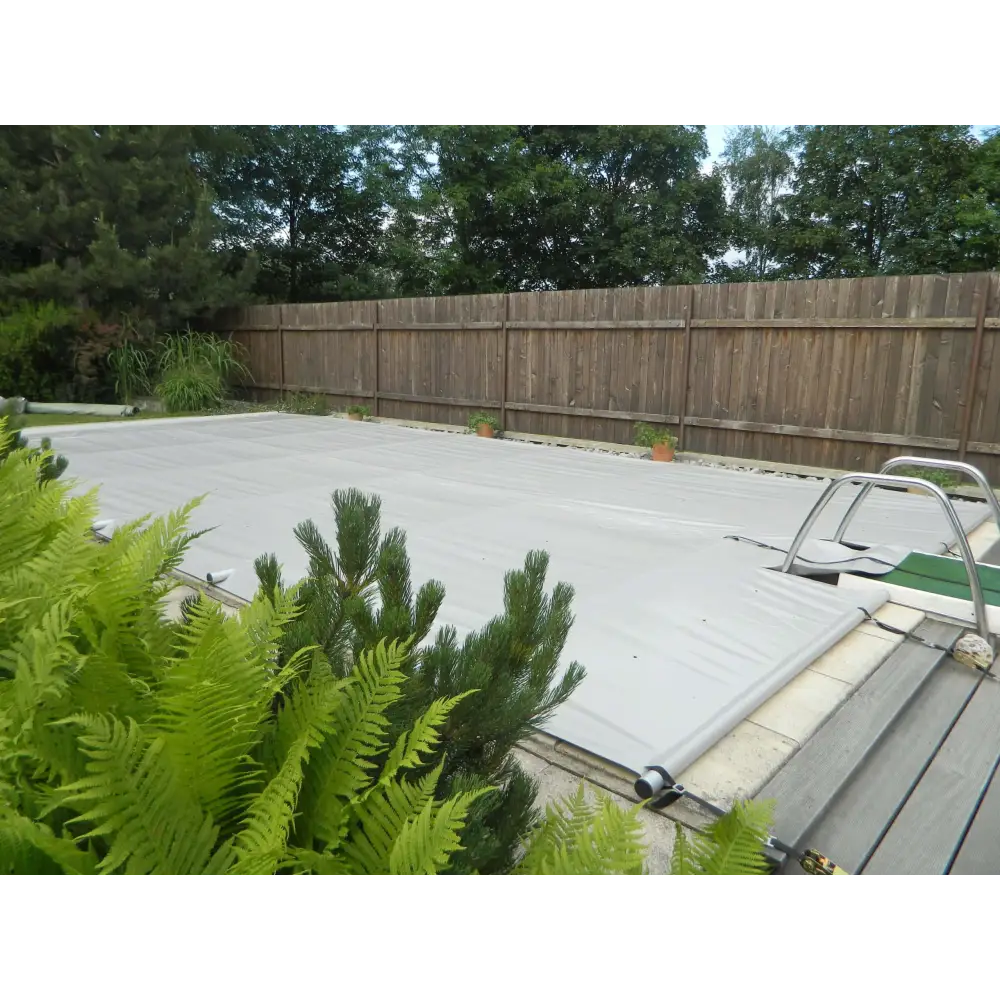 Grå pooltäckning Rolltop 3,5×7 m med ram och handkontroll, gröna växter