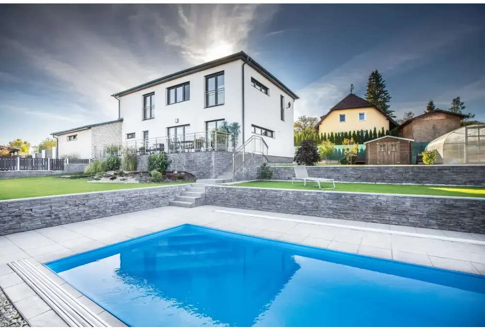 Modernt vitt tvåvåningshus med mörkgrå sten och stora fönster, Thermopp Poolpaket Qbig