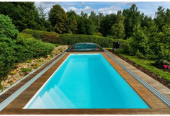 Rektangulär Thermopp Poolpaket Qbig med klart blått vatten, trädeck och grönska