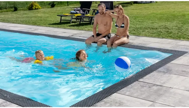 Blåvit strandboll i turkost vatten i Qbig Overflow poolpaket
